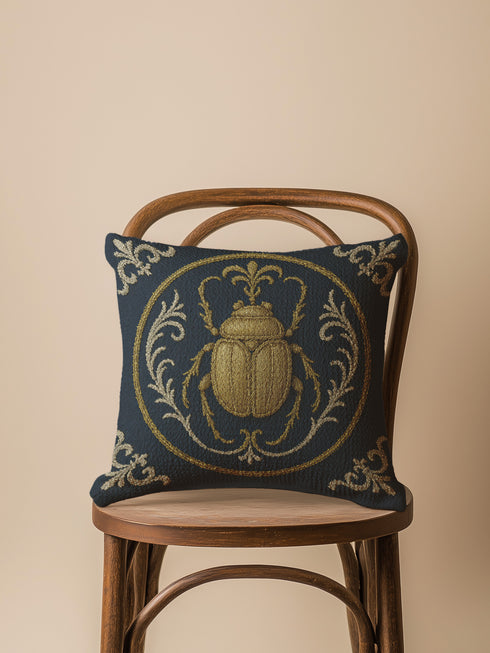 square woven tapestry pillow in charcoal grey and metallic gold thread, embodying a premium, artisan feel. The central design features a large, detailed scarab beetle, a key motif in entomology decor, encircled by ornate Victorian botanical flourishes. This combination of scholarly and mystical elements is ideal for Dark Academia, Gothic, and Whimsigoth aesthetics. The luxurious, double-sided piece of functional art is perfect as a statement pillow for a library or reading nook.